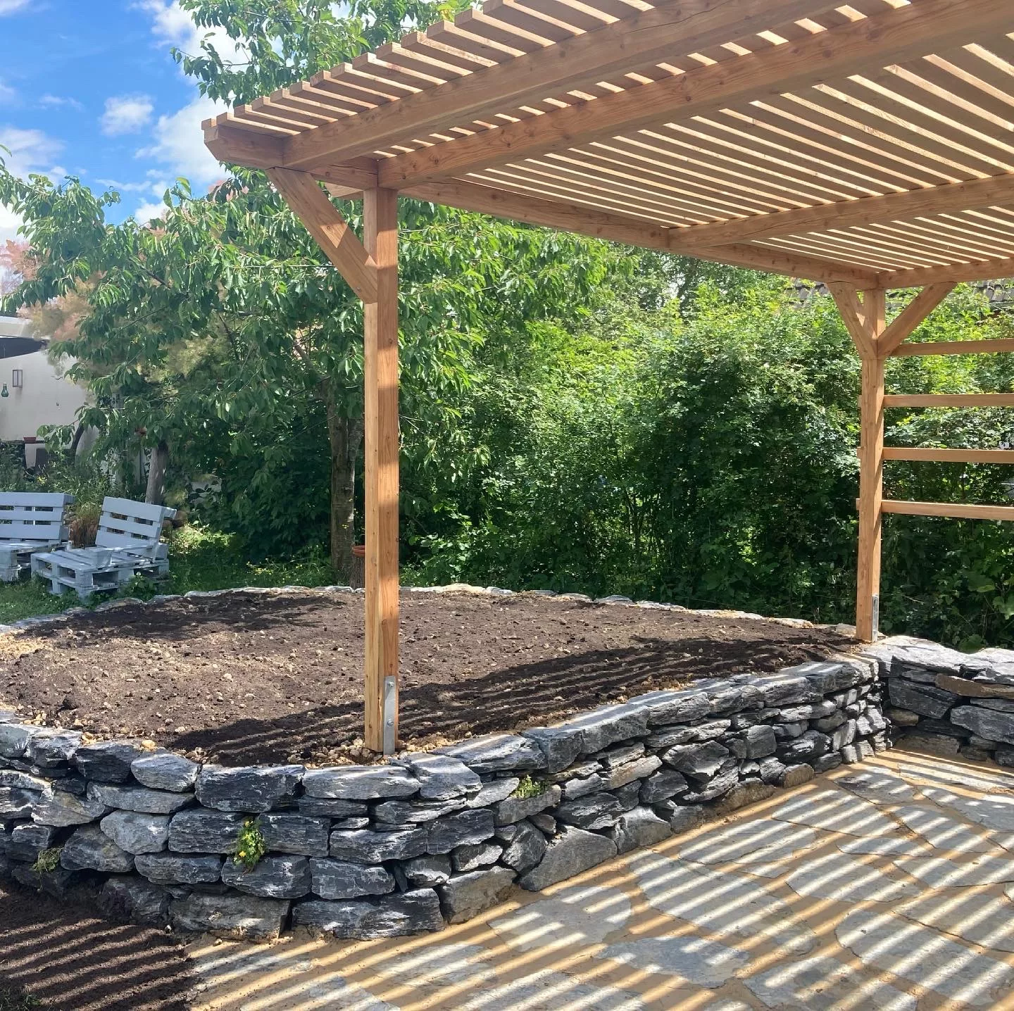 Trockenmauer aus Theumaer Schiefer und Lärchenholz-Pergola